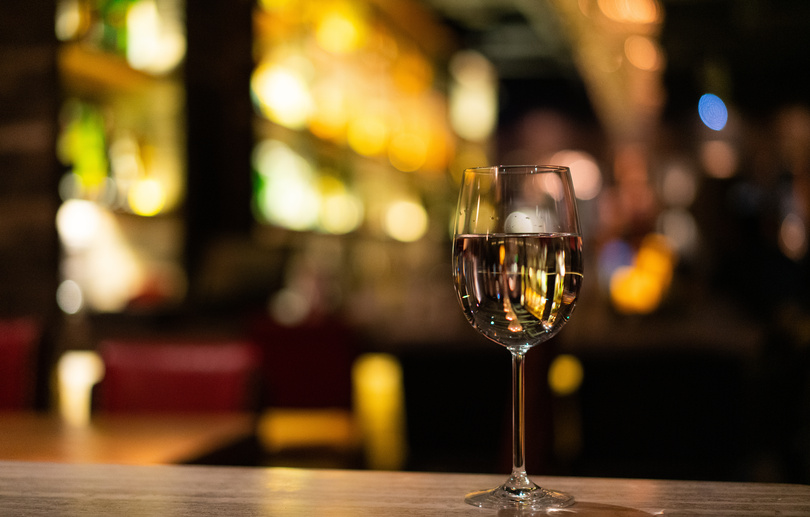 A glass of white wine at the bar counter